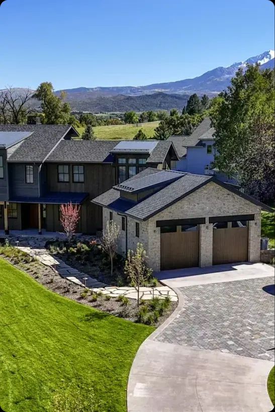 McSwain custom home with a stone garage, landscaped yard and mountain views