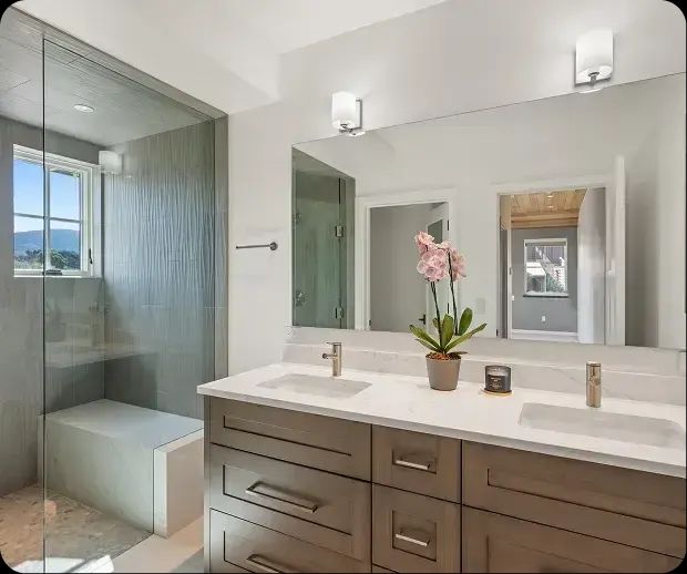 Floating wood vanity beside a glass shower