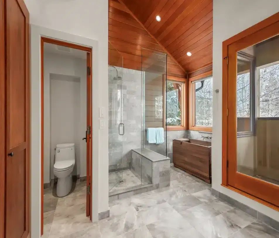 Remodeled bathroom with a glass walk-in shower, tile floor and wood ceiling