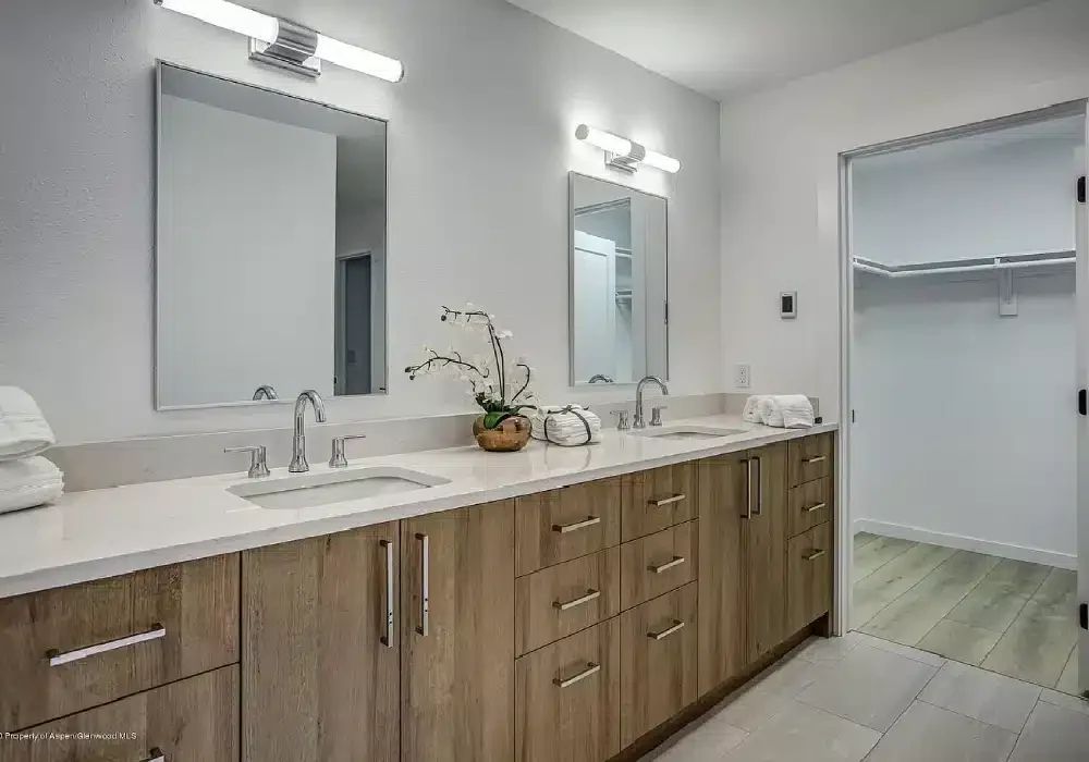Remodeled bathroom with a long double vanity and walk-in closet