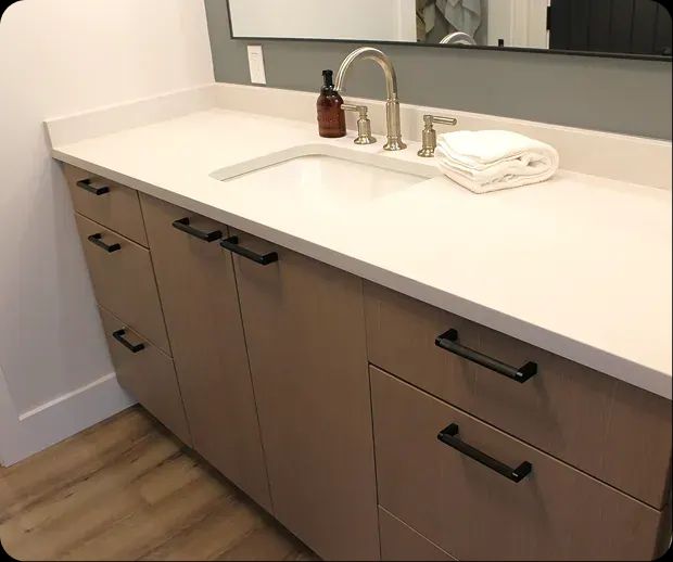 Wood vanity with quartz top and black pulls