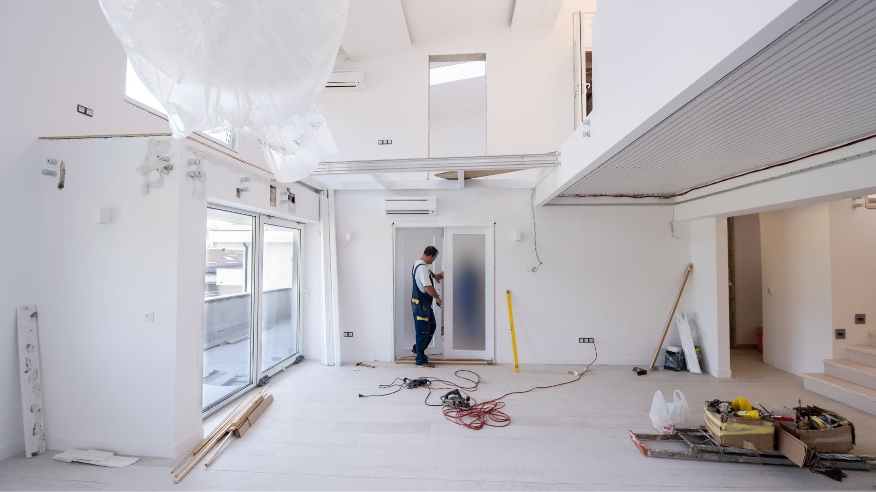 Worker fitting an interior door in a bright home under renovation