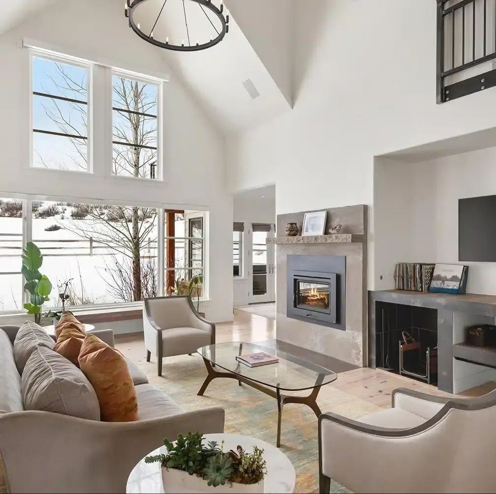 Bright living room with fireplace, built-in shelving and snowy views