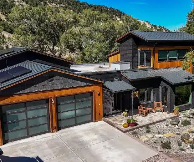 Modern mountain home with glass garage doors and solar panels