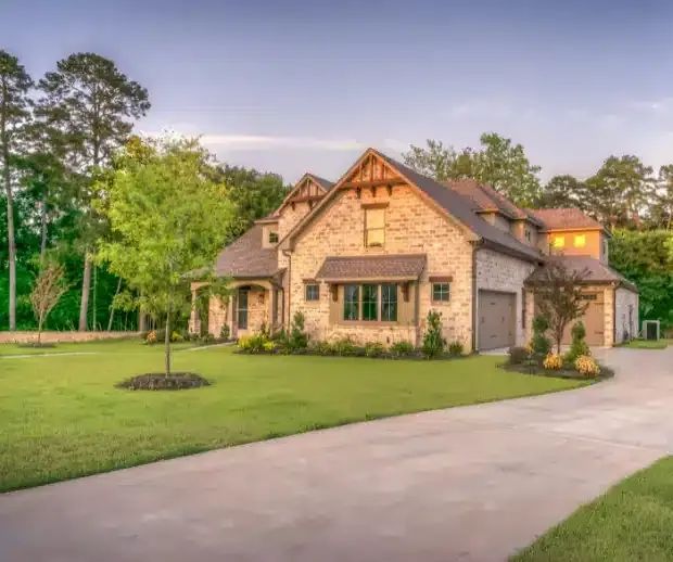 Stone and timber home with lit windows at dusk