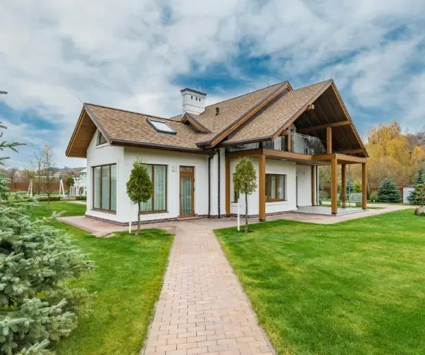 White gable home with brick walkway and lawn