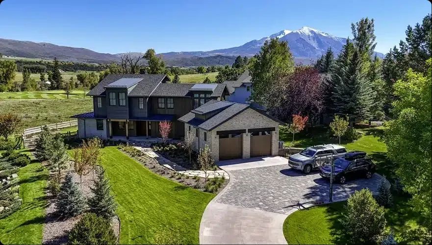 Aerial view of a remodeled mountain home with long driveway