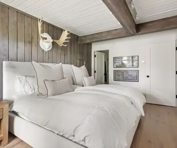 Bedroom with barnwood accent wall and timber ceiling beams