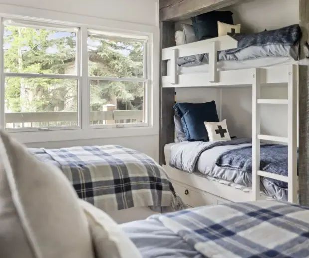Bunk room with built-in white bunk beds and plaid bedding