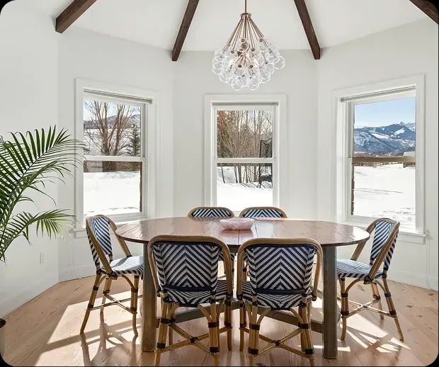 Dining room with round table, chandelier and bay windows