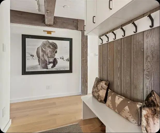 Entry bench with barnwood paneling and black coat hooks