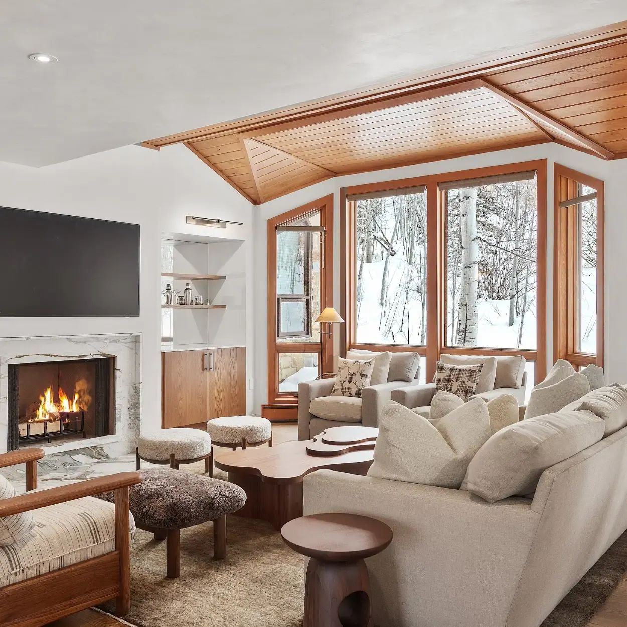 Mountain living room with cedar ceiling, fireplace and winter views