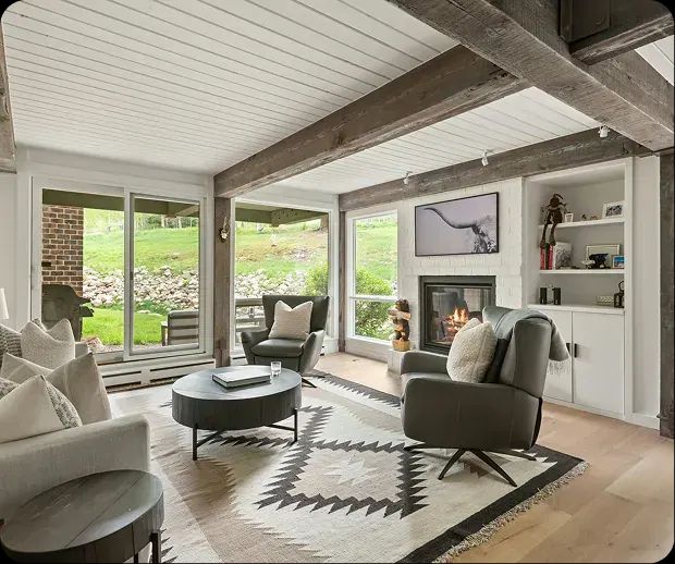 Living room with reclaimed beams, fireplace and patio doors