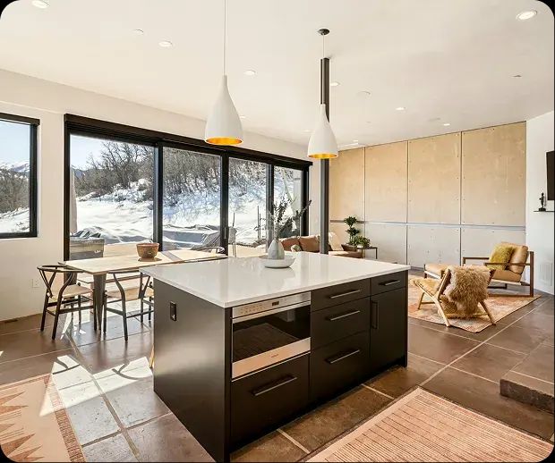 Modern kitchen with black island and floor-to-ceiling windows