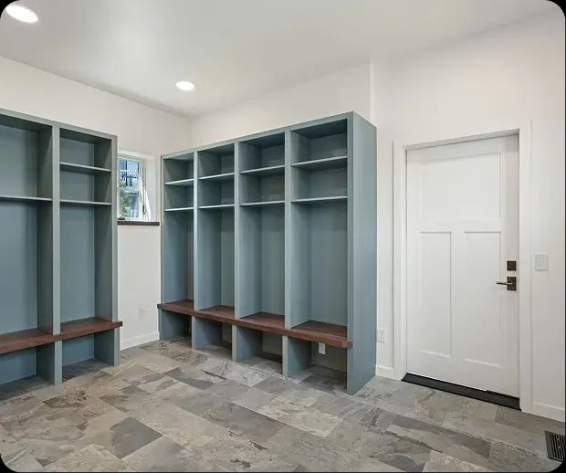 Mudroom with blue built-in lockers and slate tile floor