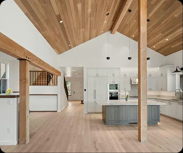 Open kitchen under a vaulted cedar ceiling with timber posts