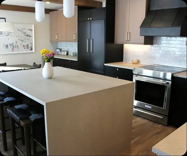 Kitchen with black cabinets and a concrete waterfall island