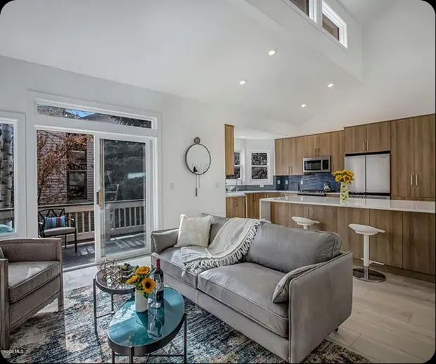 Open living room flowing into a wood-cabinet kitchen