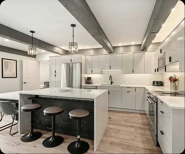 White kitchen with black island and round bar stools
