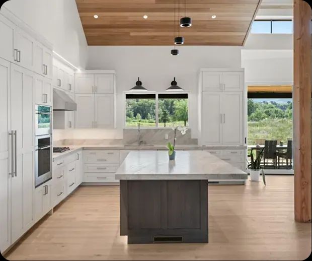 White kitchen with wood ceiling and dark island