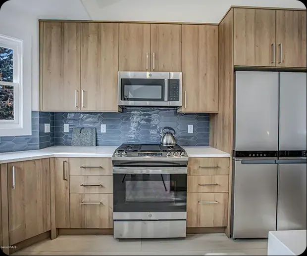 Wood cabinets with blue tile backsplash and stainless range