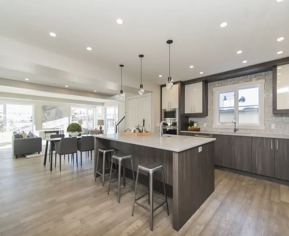 Open kitchen with a long island, pendant lights and dark wood cabinets