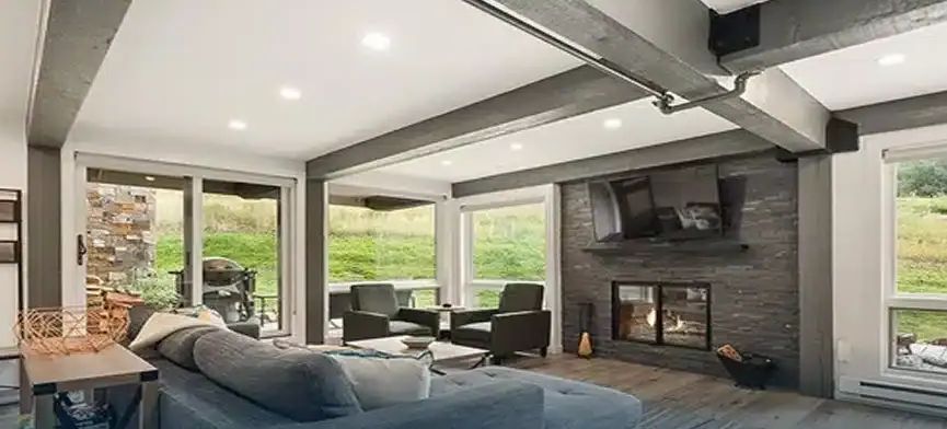 Remodeled Aspen living room with stone fireplace wall and large windows