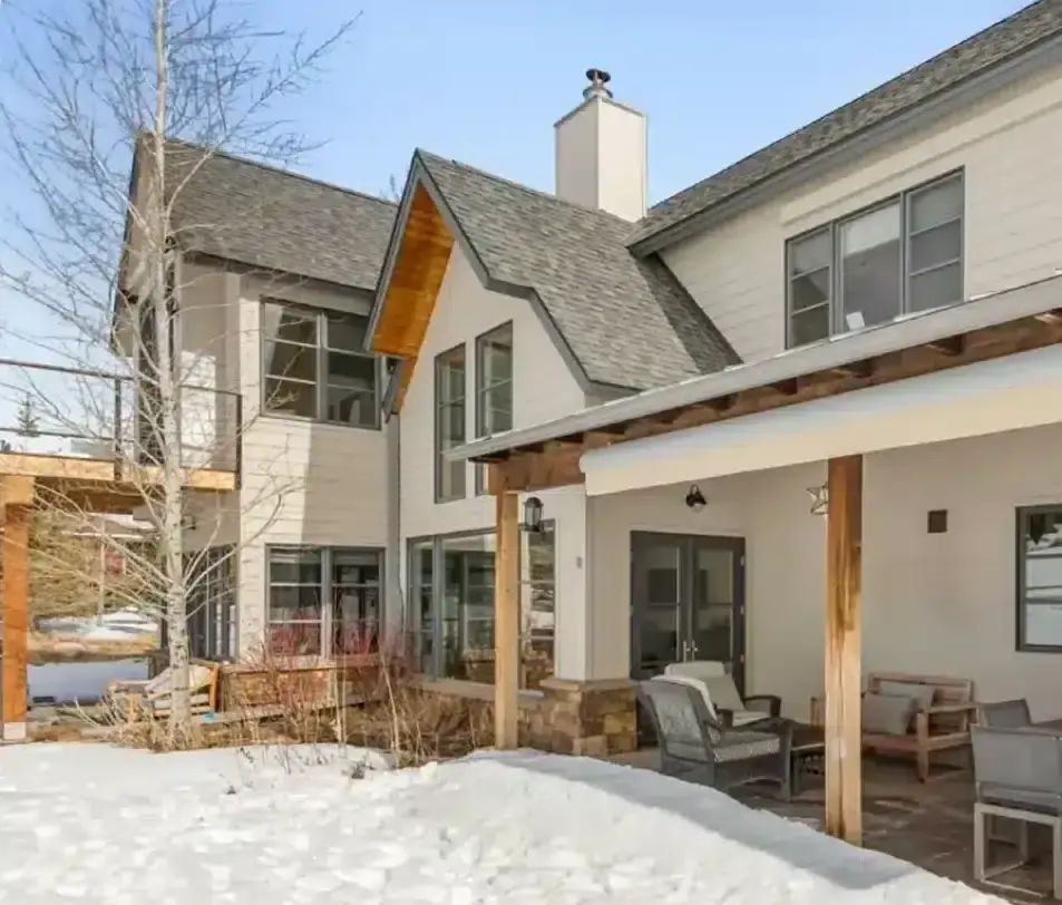 Remodeled two-story home with covered patio and a snowy backyard