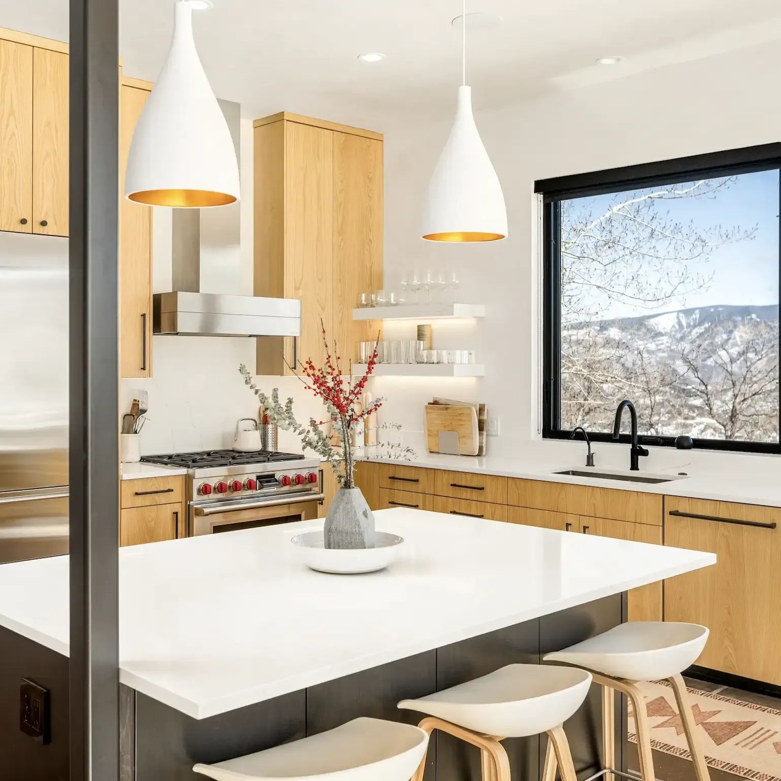 Snowmass Village kitchen remodel with wood cabinetry, white pendant lights and island seating