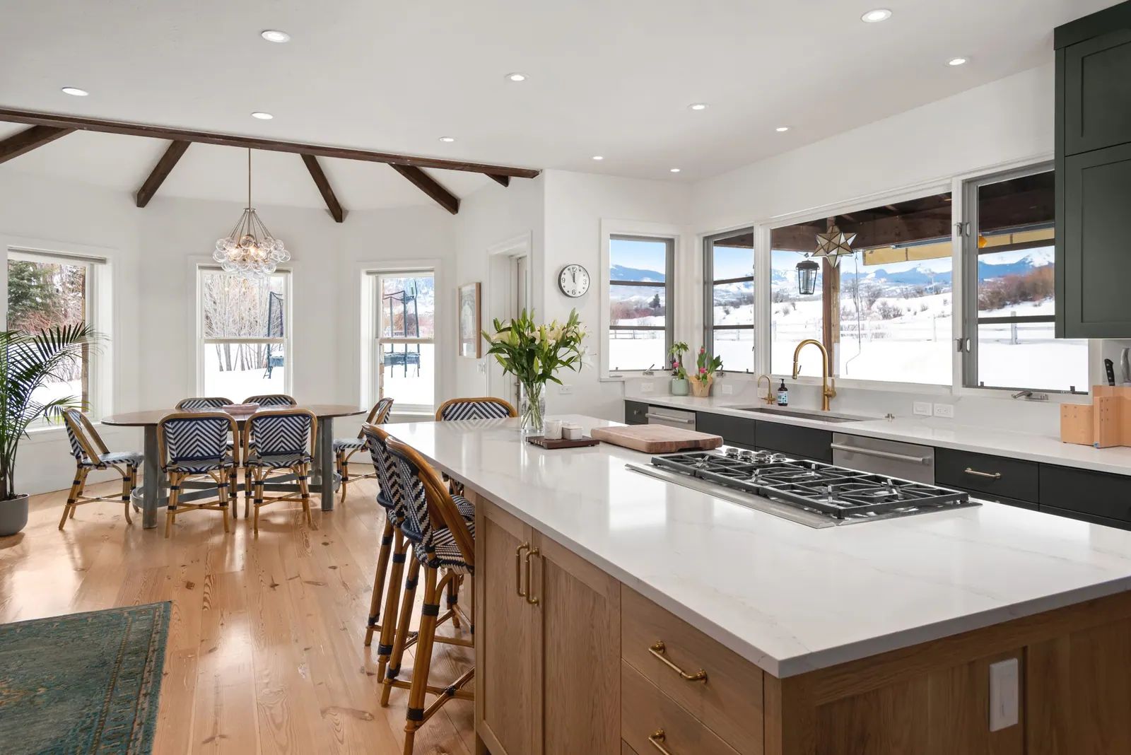 Remodeled white kitchen with a large island, gas cooktop and dining area