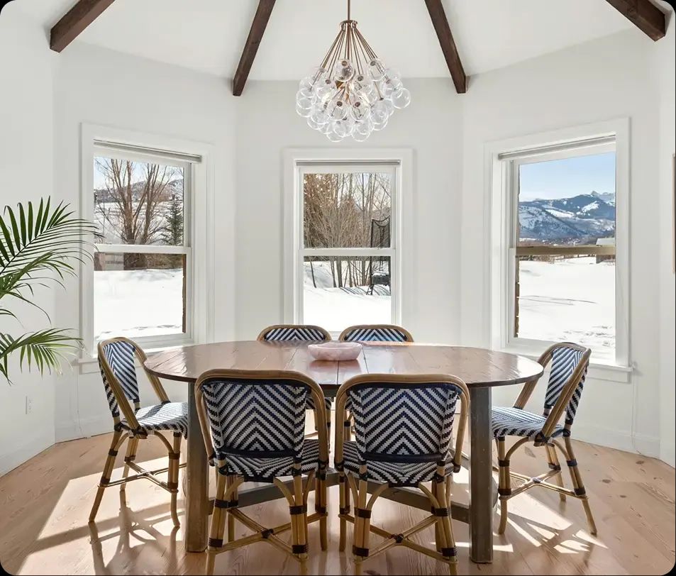 Bright dining room with a round table and snowy mountain views